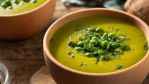 Sopa de ervilha em uma tigela marrom.