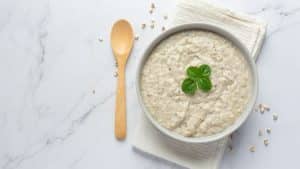 Mingau de aveia com colher de madeira.