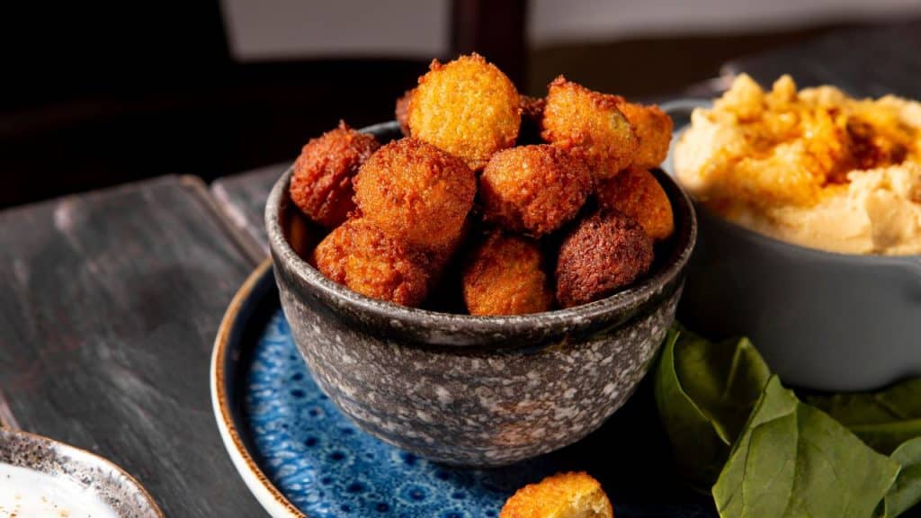 Croquete de abóbora em uma tigela cinza no balcão de uma cozinha.