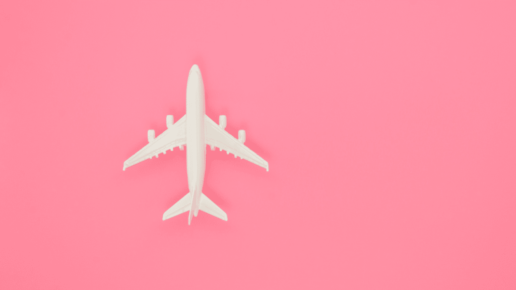 Imagem de uma miniatura de avião em um fundo rosa