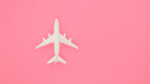 Imagem de uma miniatura de avião em um fundo rosa