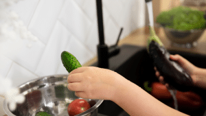 Uma mão lavando verduras