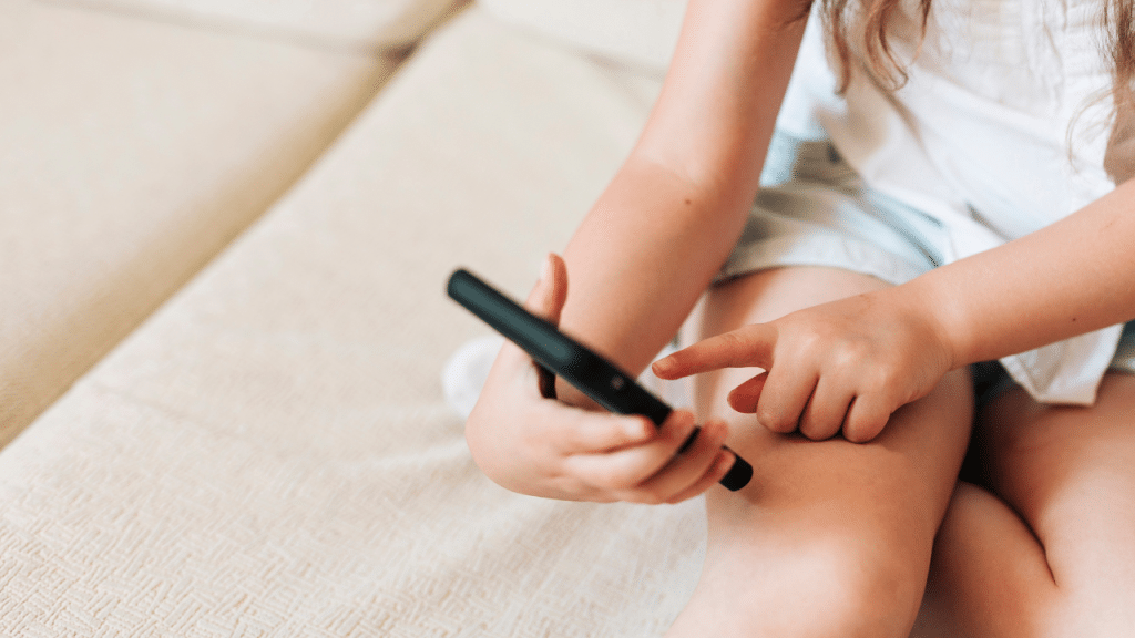 Mão de criança mexendo no celular